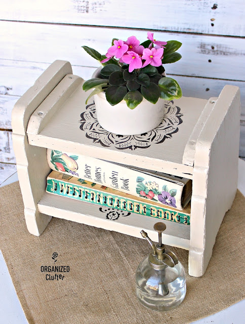 Photo of an antique footstool upcycled & repurposed as a decor/book shelf.