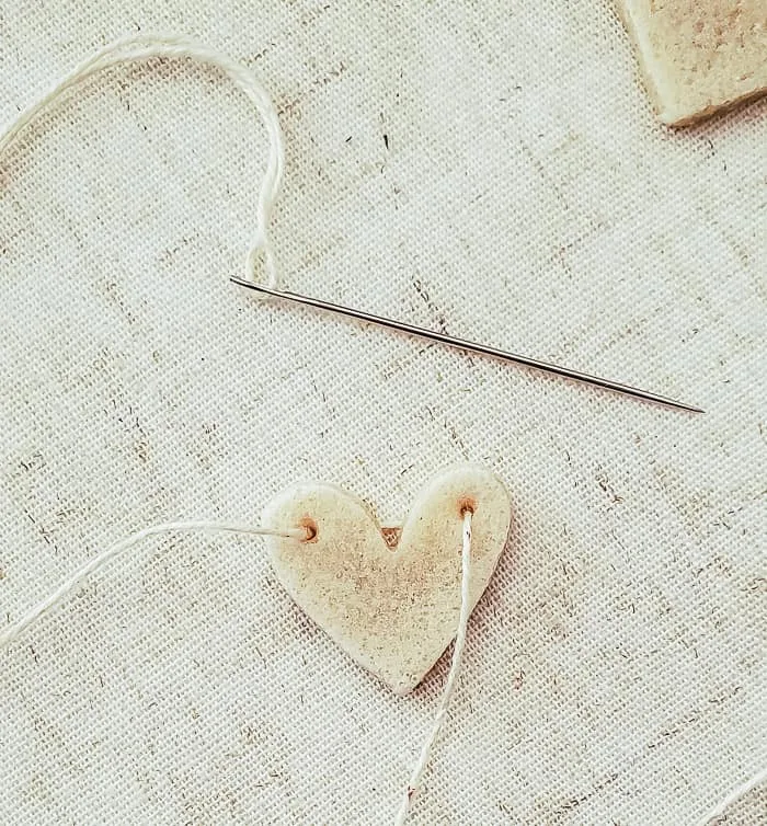 threading twine on mini salt dough heart with a needle