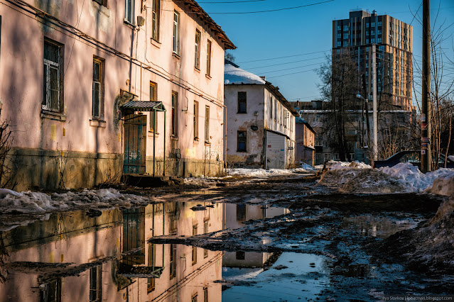 Грязь и лужа на фоне жилого дома