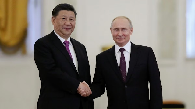 Russian President Vladimir Putin shakes hands with his Chinese counterpart Xi Jinping