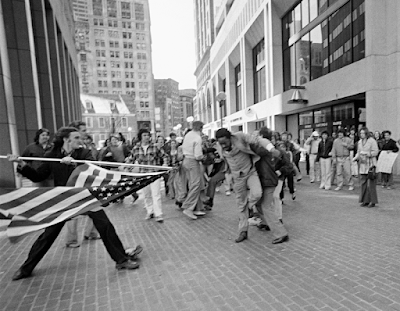 photo of  Joseph Rakes (L) uses an American flag to attack civil rights lawyer and activist Ted Landsmark (R) during protests over the Boston busing crisis, Apr. 5, 1976