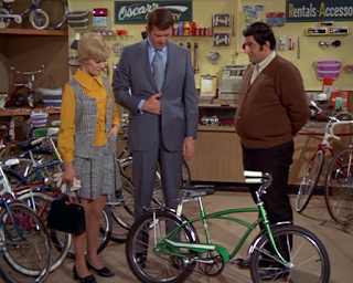 Mike and Carol Brady shop for a new bicycle for Bobby.