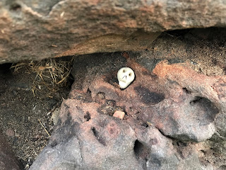 A close up picture of a small ceramic skull (Skulferatu 61) in an indentation in the worn stone of the walls of Craiglockhart Castle. Photo by Kevin Nosferatu for the Skulferatu Project.