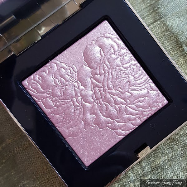 close up of Bobbi Brown Opal Glow highlighter with embossed floral design on powder