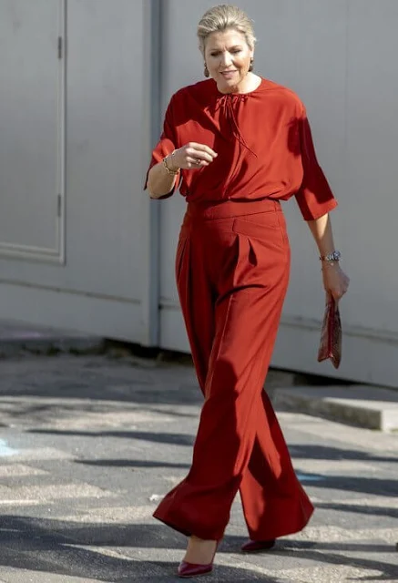 Queen Maxima wore a red silk blouse and red wide-leg trousers. Gianvito Rossi red pumps and Monies earrings. Dutch Council for Refugees