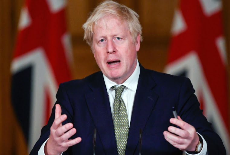Boris Johnson, the British Prime Minister, talks during a joint news conference with his Polish counterpart at the Prime Minister's Chancellery in Warsaw, Poland, in February. Seven additional Russian oligarchs, including the owner of the Chelsea soccer team, were sanctioned by the United Kingdom on Thursday. Leszek Szymanski/EPA-EFE/File Photo.