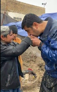 Haji Sayed Ahmad Selab, Ex Afghan MNA And Social Worker Busy In Relief Activities. Kissing A poor Child's hands