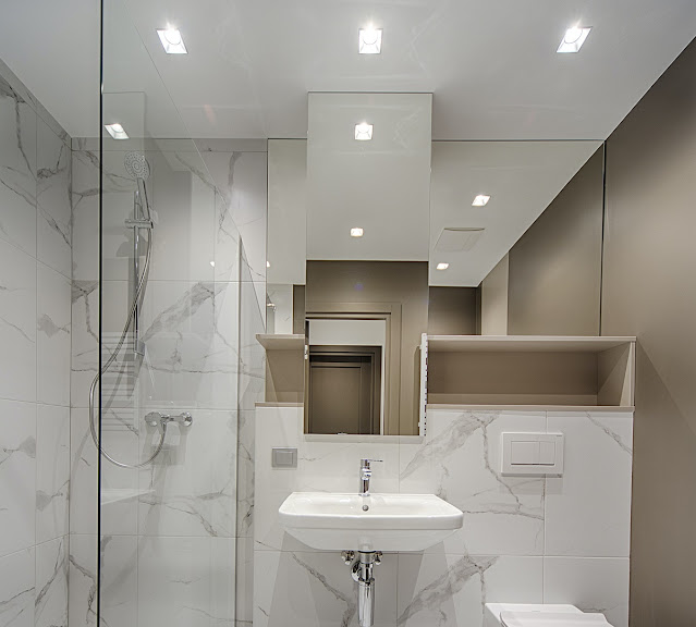 White bathroom with recessed lighting across the room.