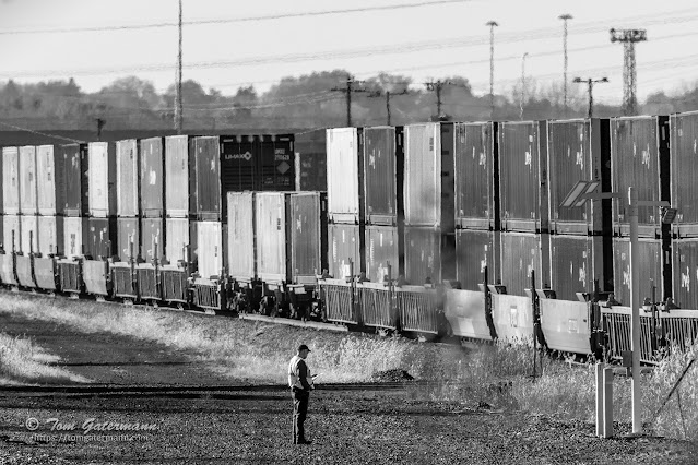 Train crew member watches as I162-06 passes by at DeWitt Yard