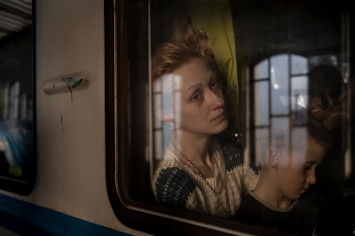 photo of woman and child through train window as the leave Ukraine for Poland