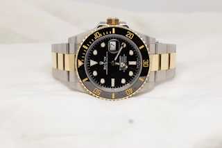 rolex watch sat on plain background