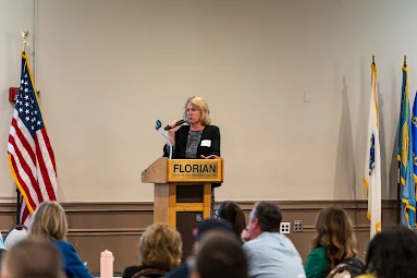 Woman speaking into microphone on stage