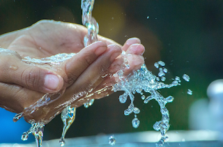 Hands under running water which splashes