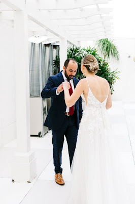 groom admiring brides dress