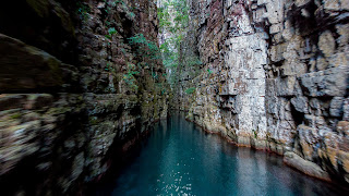 Paredones de acantilados que surgen de las aguas de un rio encajonado entre las dos paredes.