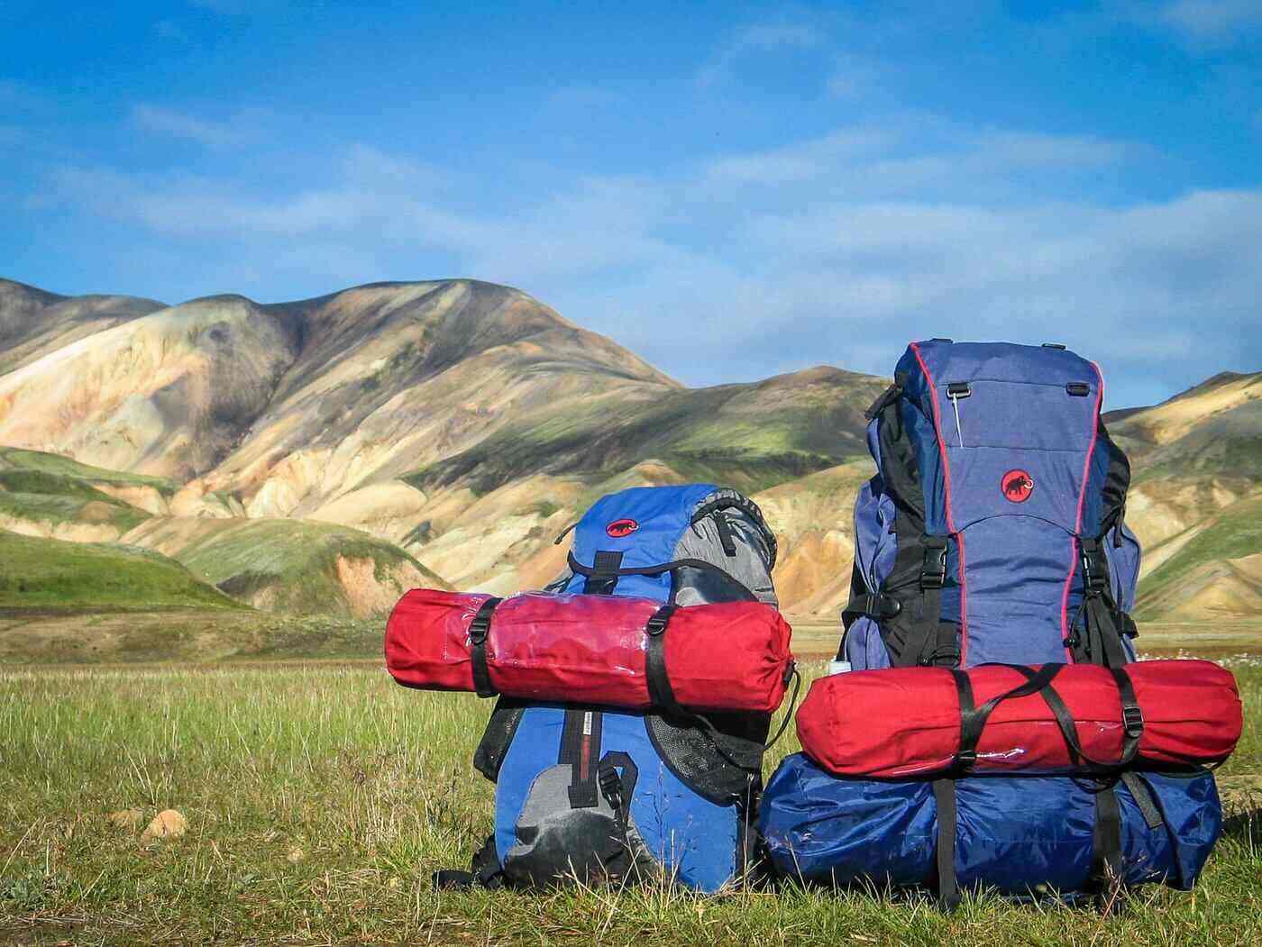 backpacks on ground in front of hills - ziplock bag on car mirror and 3 other viral travel hacks that work