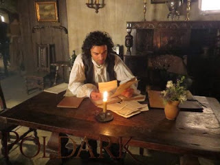 Ross Poldark at Nampara sitting at a table and reading papers and documents at a