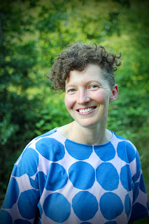 Author photograph of author Beth Underdown smiling and wearing a blue spotty top.