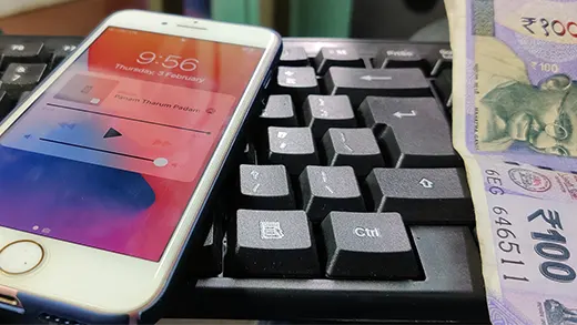 an iphone on a keyboard and a currency