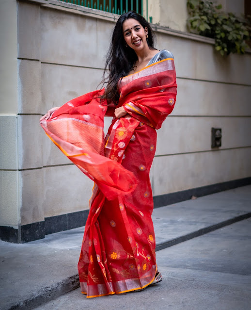 Tomato red Kota doria saree with floral vine border.