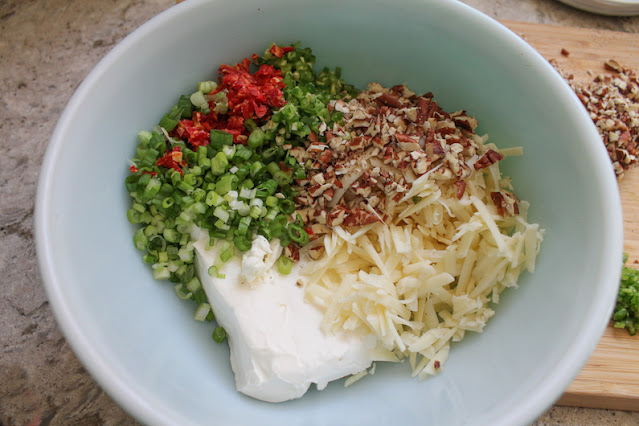 In a bowl, use a wooden spoon or stiff spatula to combine the cream cheese, cheddar cheese, one quarter of the pecans (you can just eyeball this) and the bigger piles of jalapeño, green onions and sun-dried tomatoes until thoroughly blended.