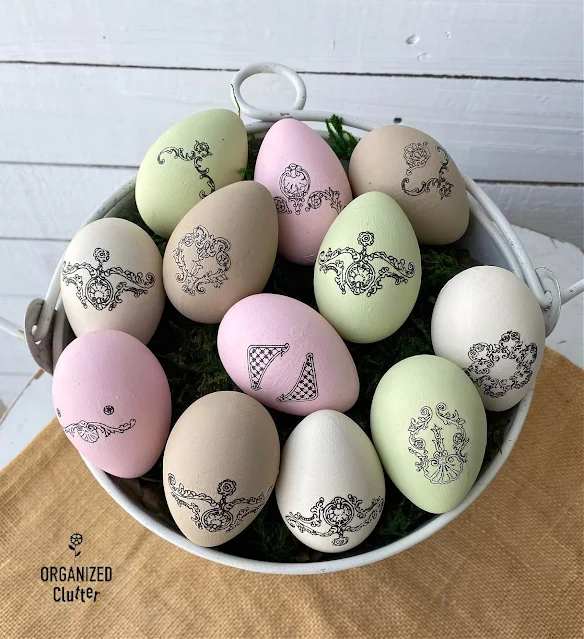 Photo of chalk painted faux Easter eggs decorated with rub on transfers.