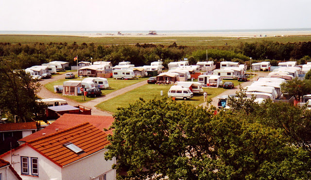 Aussenfoto Luftaufnahme über den Campingplatz Silbermöwe mit Wohnwagen und Zelten und Blick auf die Nordsee und den Strand