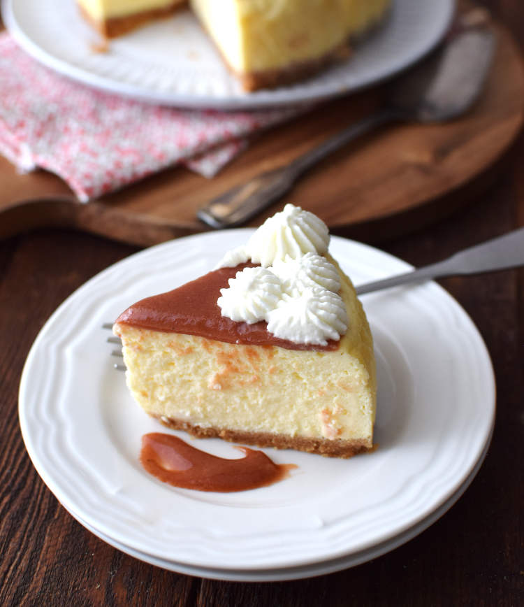 Porción de cheesecake servida con mermelada de guayaba