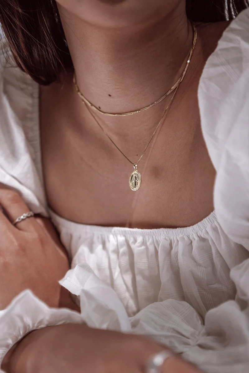 close-up of woman's neck with layered necklaces