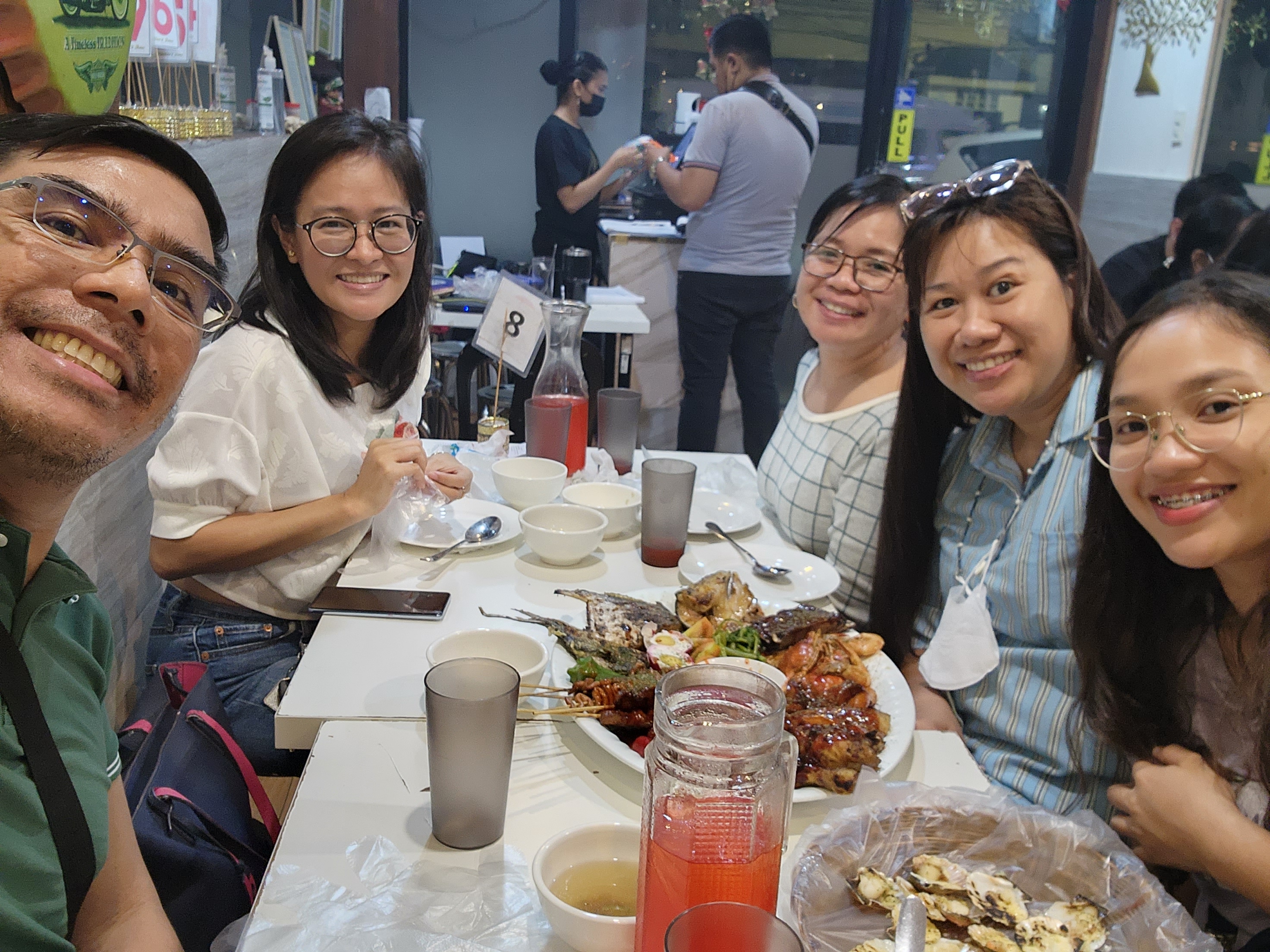 Barkada or group of friends dining and smiling at Tolentino's Unli Ihaw in Mandaluyong Branch