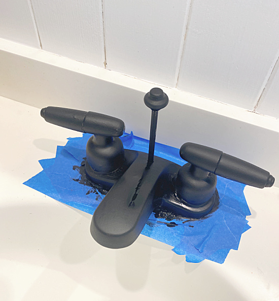 black faucet with painter's tape