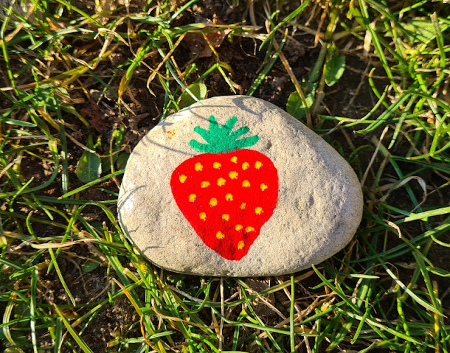 DIY-Anleitung: Steine für den Garten bemalen. Auf diesen Stein haben wir die Erdbeere gemalt, statt den Namen der Pflanze zu schreiben. So wissen auch kleine Kinder, was im Beet angepflanzt wurde.