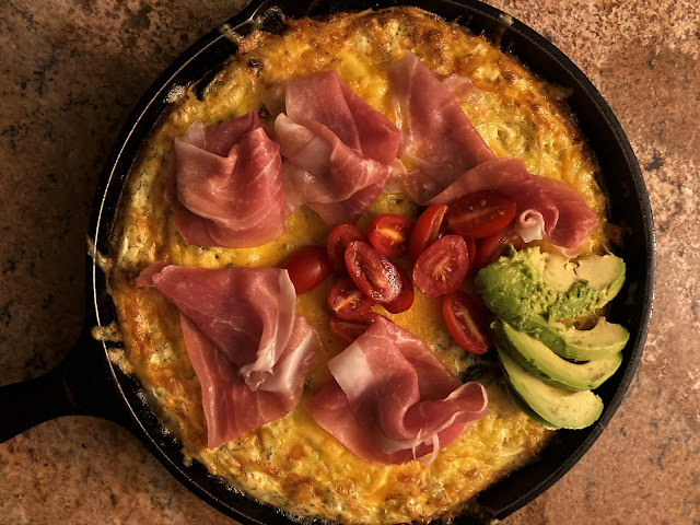 Cast iron skillet, fritatta with cheese, prosciutto, tomatoes and avocado