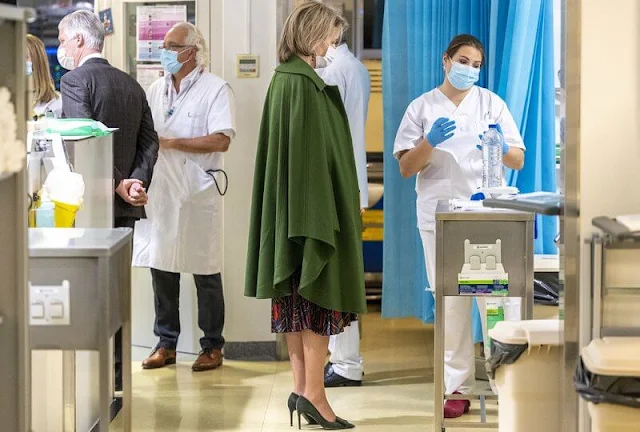 Queen Mathilde wore a wild tartan shirt dress by CH Carolina Herrera, and a green wool cashmere coat by Natan. Caritas Secours