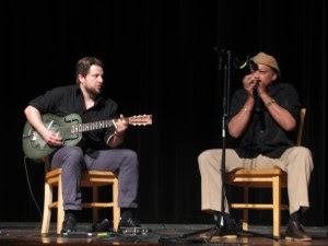 Dan Carelli playing guitar and Billy Branch playing the harmonica on May 14, 2015, at Harold Washington Library Center's Cindy Pritzker Auditorium, Chicago, Illinois