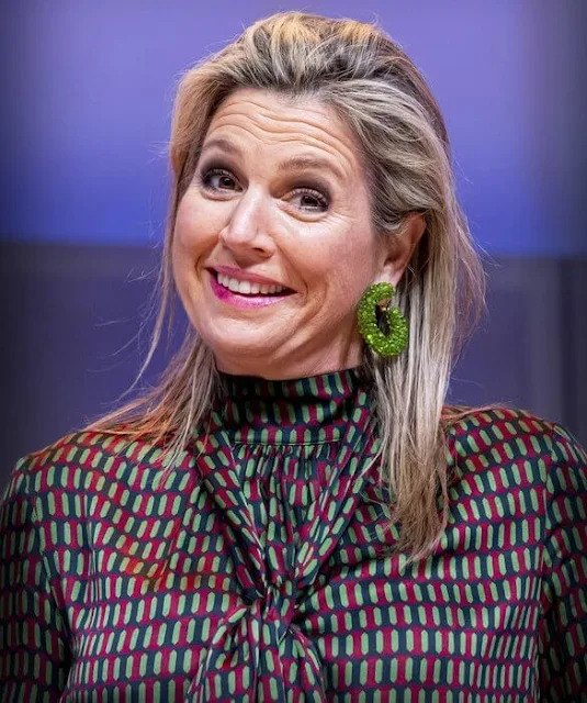 Queen Maxima wore a geometrical print viscose blouse from Natan, and a green leather skirt. Navy wool coat. Bodes and Bode earrings