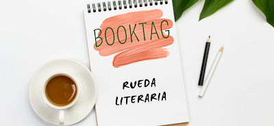 Una libreta con una taza de café y un lápiza. En la libreta dice BookTag: Rueda literaria