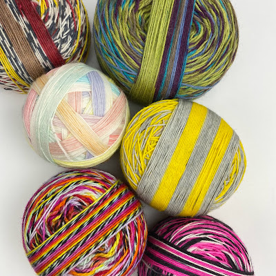 cakes of hand dyed yarn with ends wound inn opposite direction to show stripes