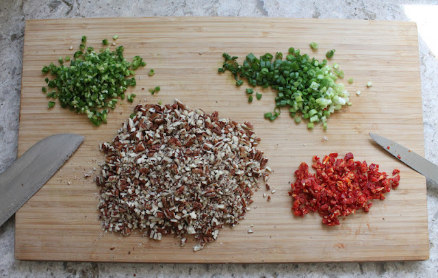 Finely mince the jalapeño, green onions and sun-dried tomatoes. Separate out about 1 tablespoon each of the vegetables to be used later when we roll the cheese ball.   Chop the pecans finely.