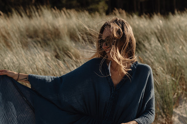 Woman in grassy field with a flowing shawl