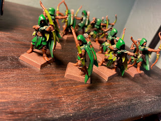 A different angle on 10 hooded elves with bows, painted in two shades of green.