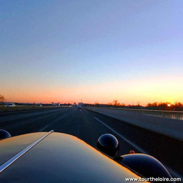 Driving a Citroen Traction Avant over the Loire into the sunset at Tours, Indre et Loire, France. Photo by Loire Valley Time Travel.