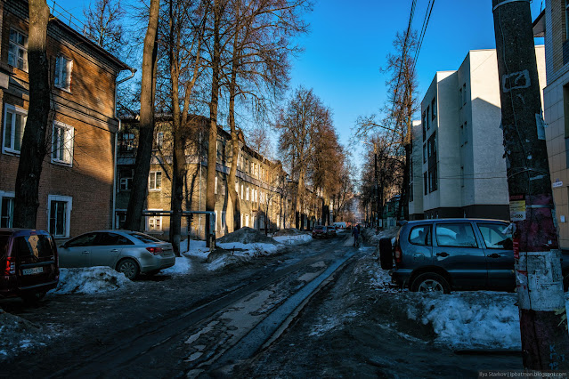 Улица, припаркованные машины и трехэтажные дома