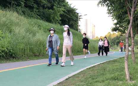 People walk along a stream, doing workout and exercise