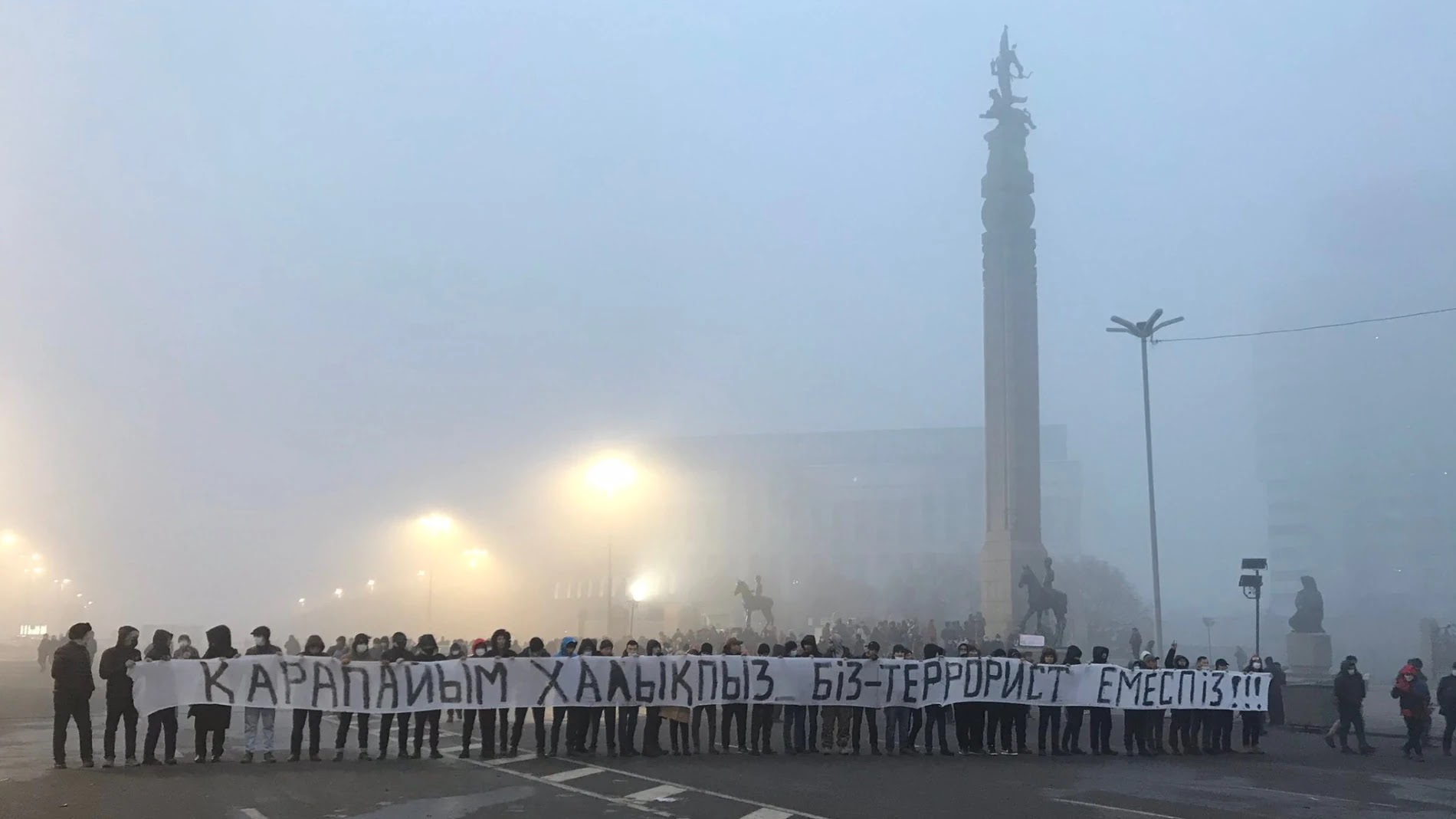 Протестующие в Алматы с транспарантом «Мы - простые люди, мы - не террористы». 6 января 2022 года