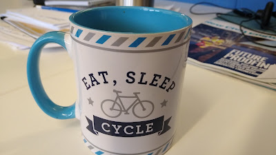 A mug which says "east, sleep, cycle"