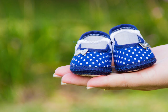 Hand holding baby shoes