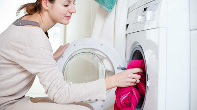 woman-loading-red-clothes-into-dryer-electicity