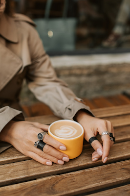 A Woman Taking Coffee and Wearing Metal and Leather Rings