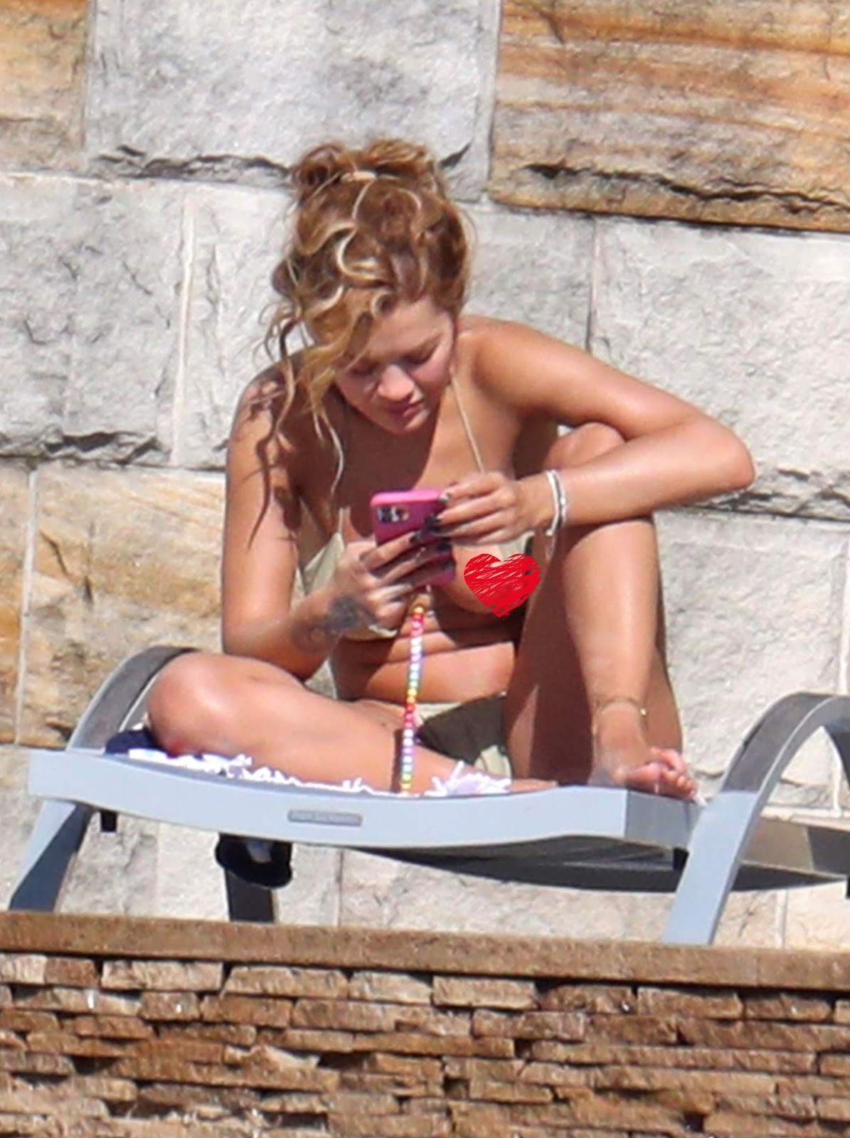 Rita Ora suffers a nip slip in a gold bikini at her hotel in Sydney.